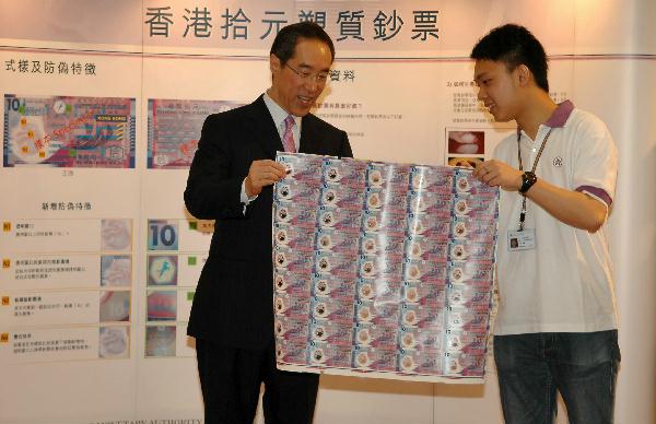 財政司司長唐英年今日(六月十五日)下午到鯉魚門廣場參觀香港拾元塑質鈔票展覽。該展覽為金融管理局拾元塑質鈔票全港社區推廣活動項目,學生大使將前往不同社區的商戶派發小冊子,進一步加强公眾對新鈔票的認識。圖示學生大使向唐英年展示新拾元塑質鈔票。